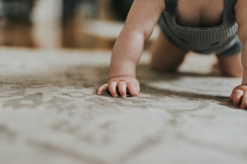 a baby crawling on a carpet